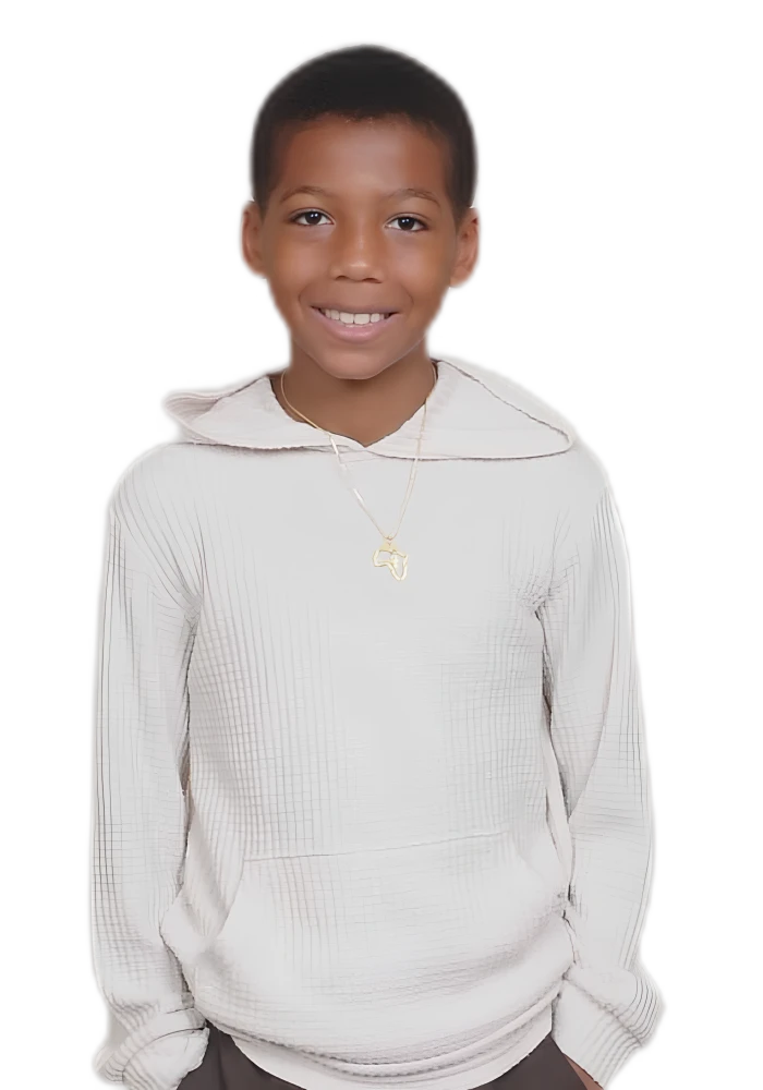 Zayden smiling in a cream hoodie with an Africa pendant